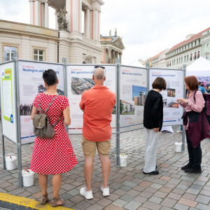Personen schauen sich die Ausstellung der PWG Geschichte an